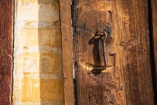 Detail of rusty iron Hook, on a vintage wooden door