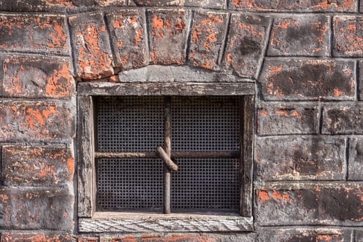 old window in the building with cross bars on the window to avoid unwelcome intrusion