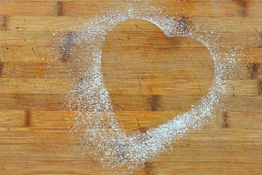 Photo a heart of icing sugar on wood