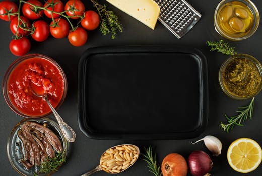 Fresh vegetables and ingredients for cooking pasta on black background, place for text. Vegan food , vegetarian and healthy cooking concept.