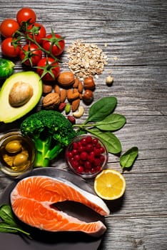 Mixed fresh healthy food on wooden background - heart concept