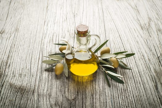 Olive oil and olive branch on the wooden table