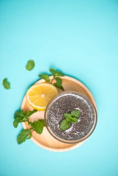 Selective focus of chia seeds drink with water in transparent glass with lemon balm.