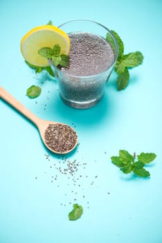 Selective focus of chia seeds drink with water in transparent glass with lemon balm.
