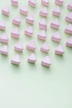 Valentines Day candy hearts marshmallows over green background