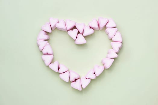 Valentines Day candy hearts marshmallows over green background