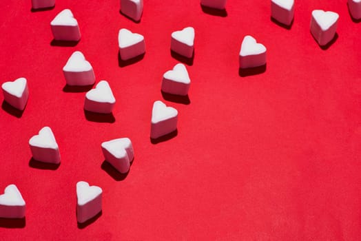 Valentines Day candy hearts marshmallows over red background