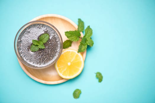 Selective focus of chia seeds drink with water in transparent glass with lemon balm.