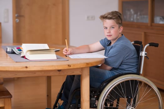 disabled boy in wheelchair doing homework