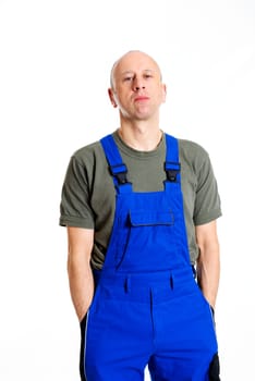 young workman in blue dungarees in front of white background