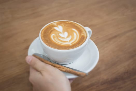 Hand On Hot Cup Of Coffee Latte, stock photo