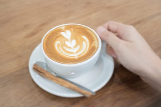 Hand On Hot Cup Of Coffee Latte, stock photo