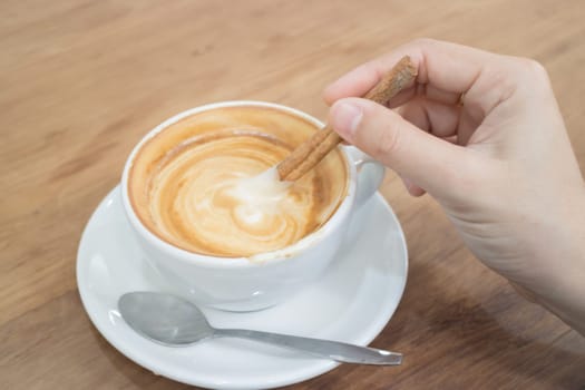 Hand On Hot Cup Of Coffee Latte, stock photo