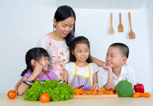 Asian mother and children cooking in the kitchen