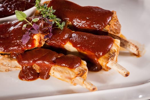 Grilled pork ribs Spareribs with barbecue sauce marinade and herb salad on a plate