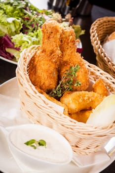 Crispy fried chicken wings with a dip on a plate