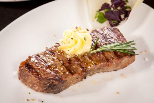 Succulent grilled beef fillet steak with homemade herb butter on a plate