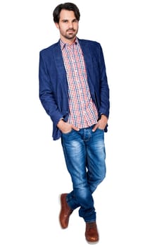 Young man in trendy casual look with dark hair and beard isolated against a white background
