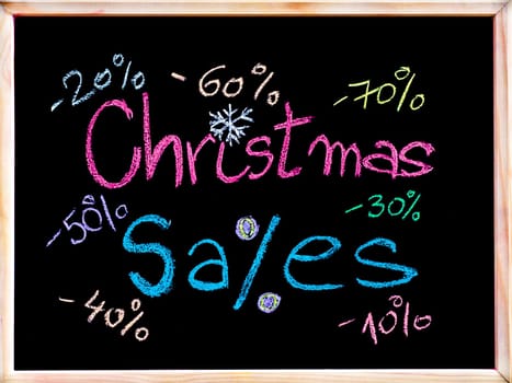 Sales conceptual image with discount figures around Christmas Sales text. Colorful Hand drawing on blackboard, isolated on black background, horizontal shot, holiday sale concept