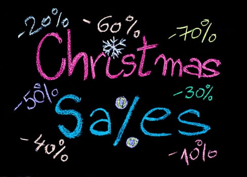 Sales conceptual image with discount figures around Christmas Sales text. Colorful Hand drawing on blackboard, isolated on black background, horizontal shot, holiday sale concept