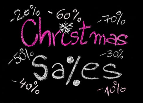Sales conceptual image with discount figures around Christmas Sales text. Colorful Hand drawing on blackboard, isolated on black background, horizontal shot, holiday sale concept