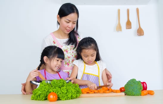 Asian mother and children cooking in the kitchen