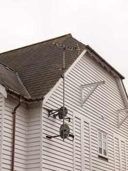 a tv ariel and black sky dishes attached to a house picking up reception outside entertainment family fun bills england barn white wood walls windows