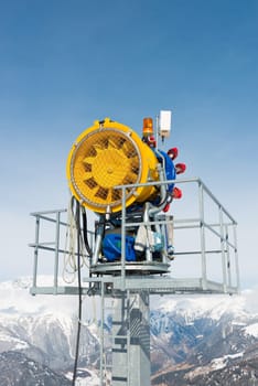Snow cannon in front of a blue sky