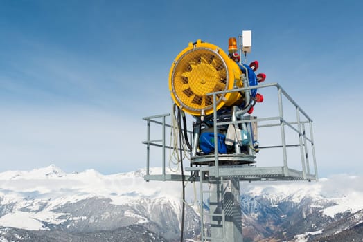 Snow cannon in front of a blue sky
