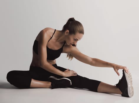 Shot of a young woman doing stretching exercises