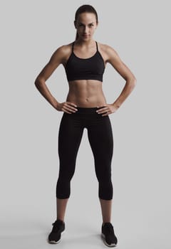 Portrait of sporty young woman with muscular body looking at camera