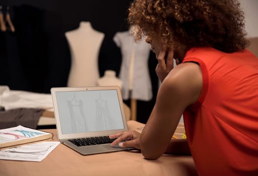 A young fashion designer working on her atelier