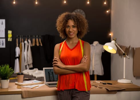 Portrait of a young fashion designer working on her atelier