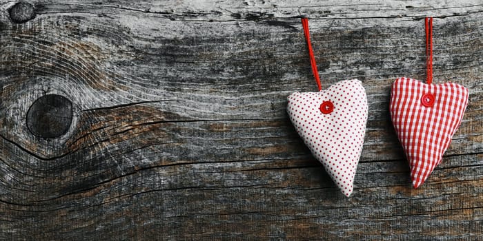 Two white-red fabric hearts on a dark wooden background in 18:9 format