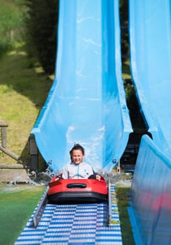 THE HAGUE, NETHERLANDS - JULI 3, 2016: Girl enjoying a water slide in a theme park in the netherlands