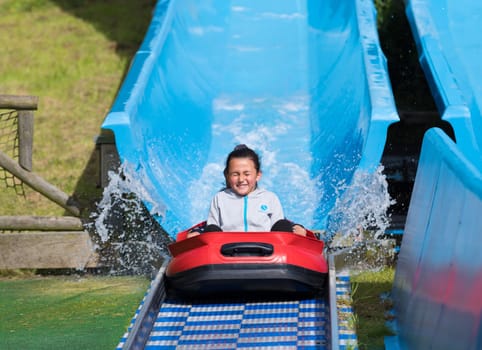 THE HAGUE, NETHERLANDS - JULI 3, 2016: Girl enjoying a water slide in a theme park in the netherlands
