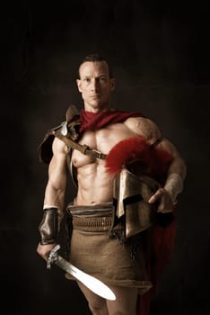 Ancient warrior or Gladiator posing over a dark background