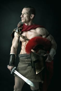 Ancient warrior or Gladiator posing over a dark background