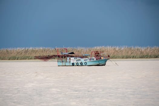 Fishing boat moving through the river on cloudy day