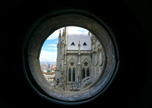 View of the Basilica of the National Vow in Quito, Ecuador as seen from a small round window