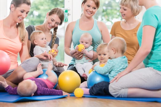 Young women in mother and child group playing with their baby kids