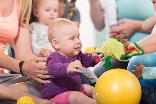 Young women in mother and child group playing with their baby kids