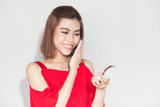 Fashion lifestyle portrait of young asian woman holding foundation cosmetic product