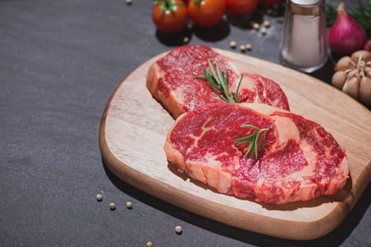 Raw beef on a cutting board  with spices and ingredients for cooking.