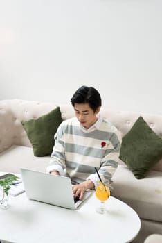 Asian young businessman working on his laptop in a coffee shop
