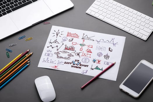 Creative sketch in spiral notepad with laptop on desk. Business idea concept