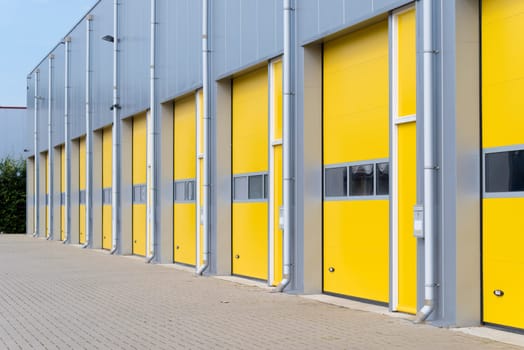 exterior of a commercial warehouse with yellow roller doors