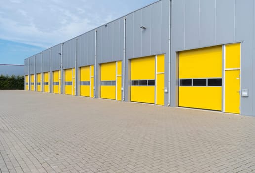 exterior of a commercial warehouse with yellow roller doors