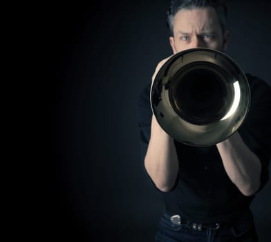 Dark portrait of a musician with a brass instrument