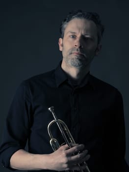 Dark portrait of a musician with a brass instrument